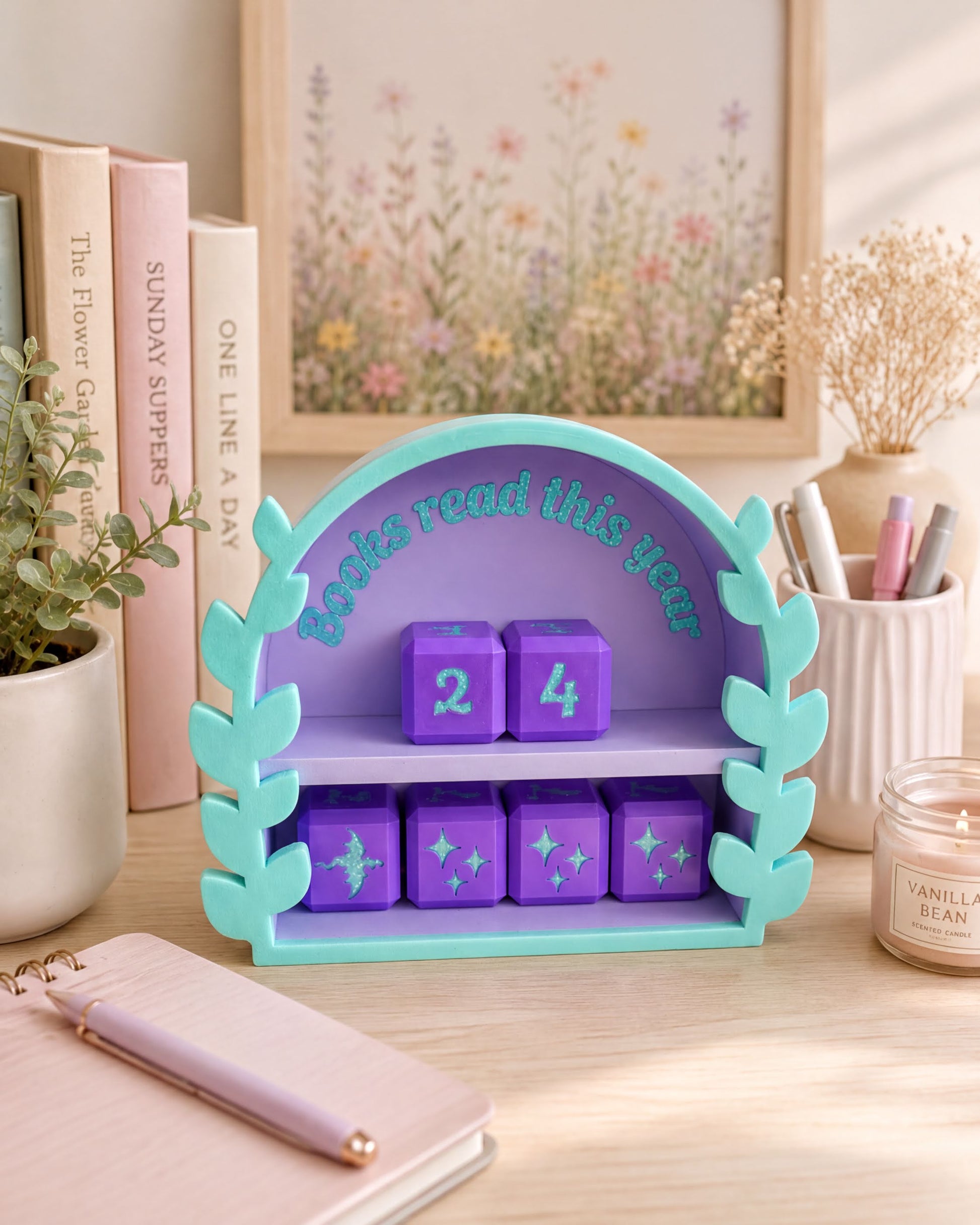 A colorful bookshelf with a purple arch and a purple book titled "Books read this year" on it, surrounded by various books, a candle, and some decorative elements.