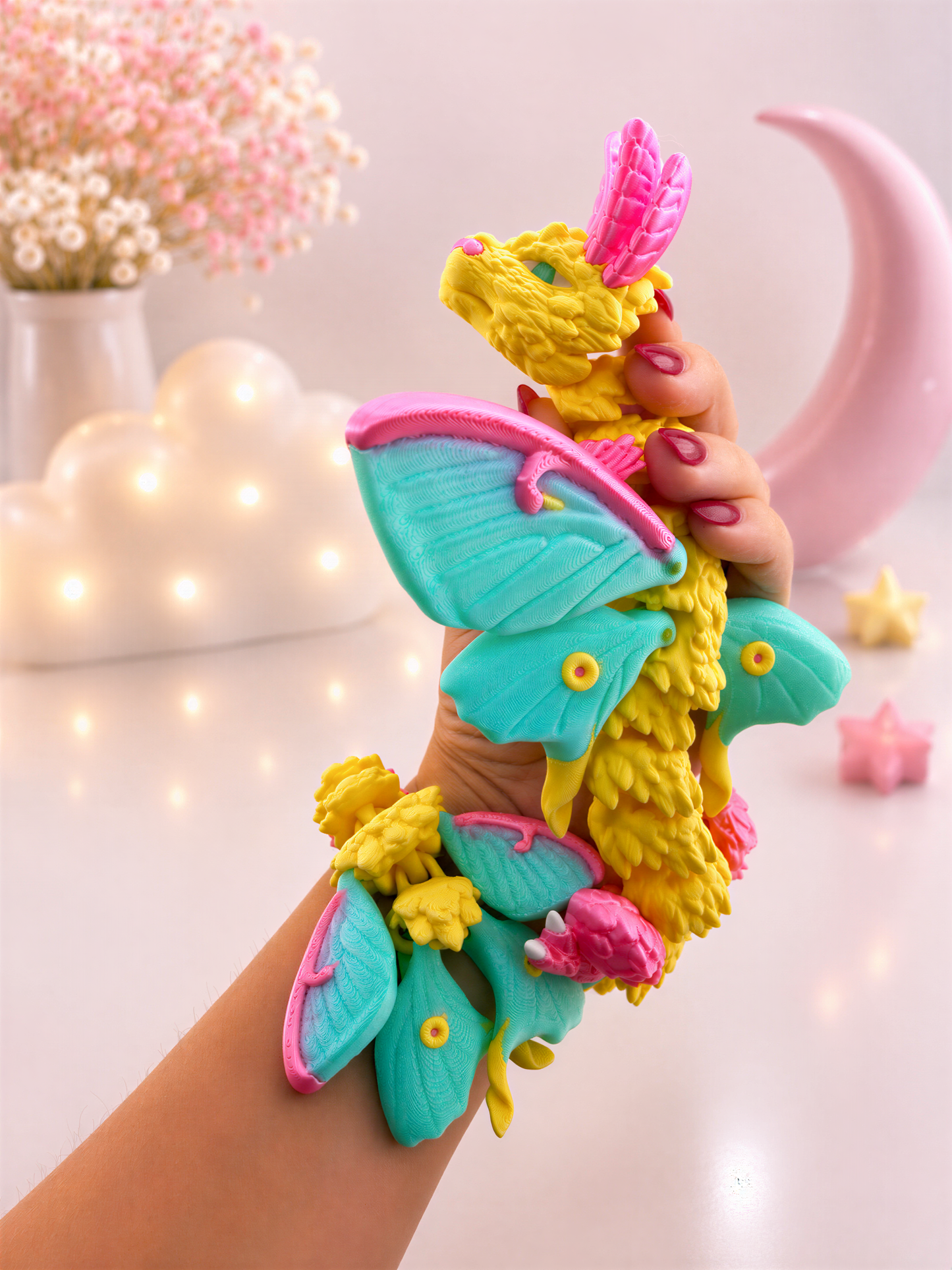 A hand holding a colorful dragon-shaped toy with wings and other decorative elements.