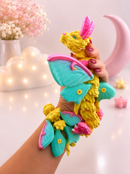 A hand holding a colorful dragon-shaped toy with wings and other decorative elements.
