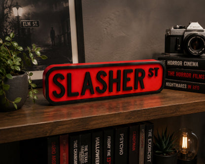 a shelf with a red sign that says "SLASHER ST", surrounded by various books and a camera.