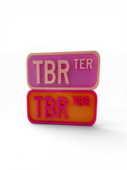 two rectangular tags with the text "TBR" in pink and orange colors.