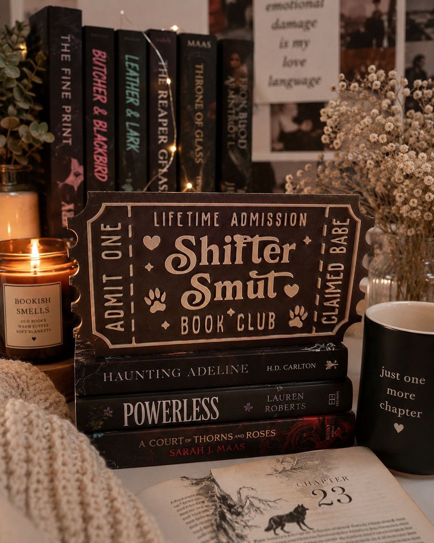 a collection of books, a candle, and a mug, all arranged on a table.