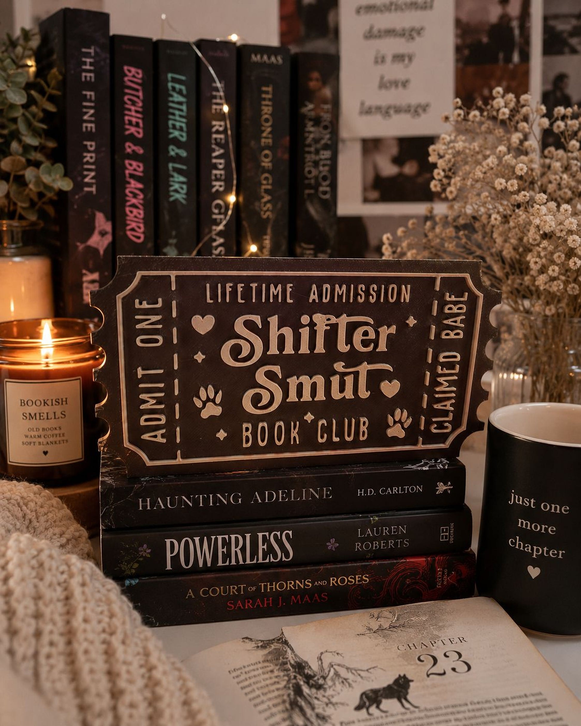 a collection of books, a candle, and a mug, all arranged on a table.