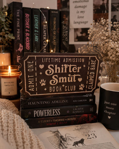 a collection of books, a candle, and a mug, all arranged on a table.