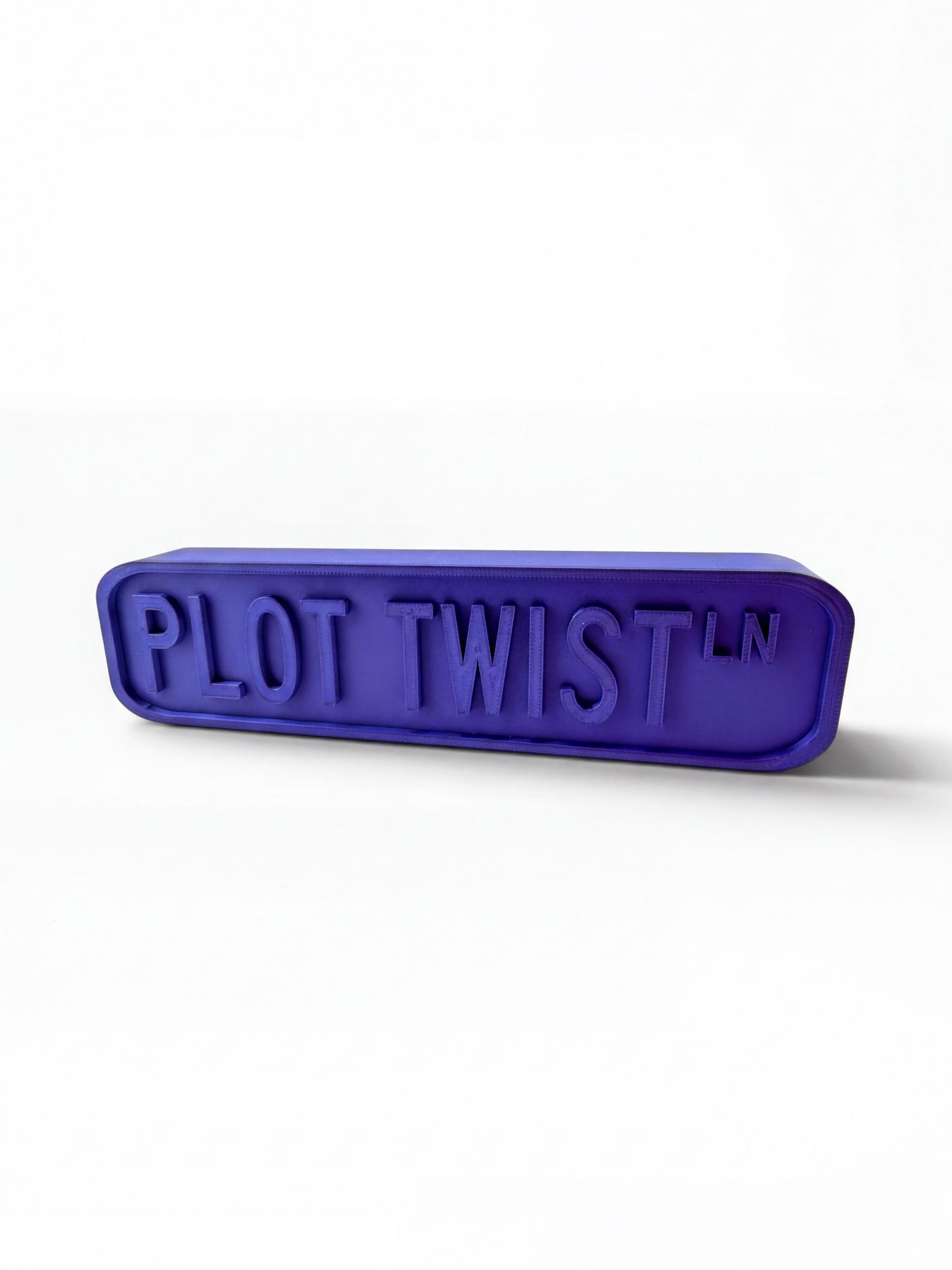 A purple rectangular object with the text "PLOT TWIST" embossed on it.