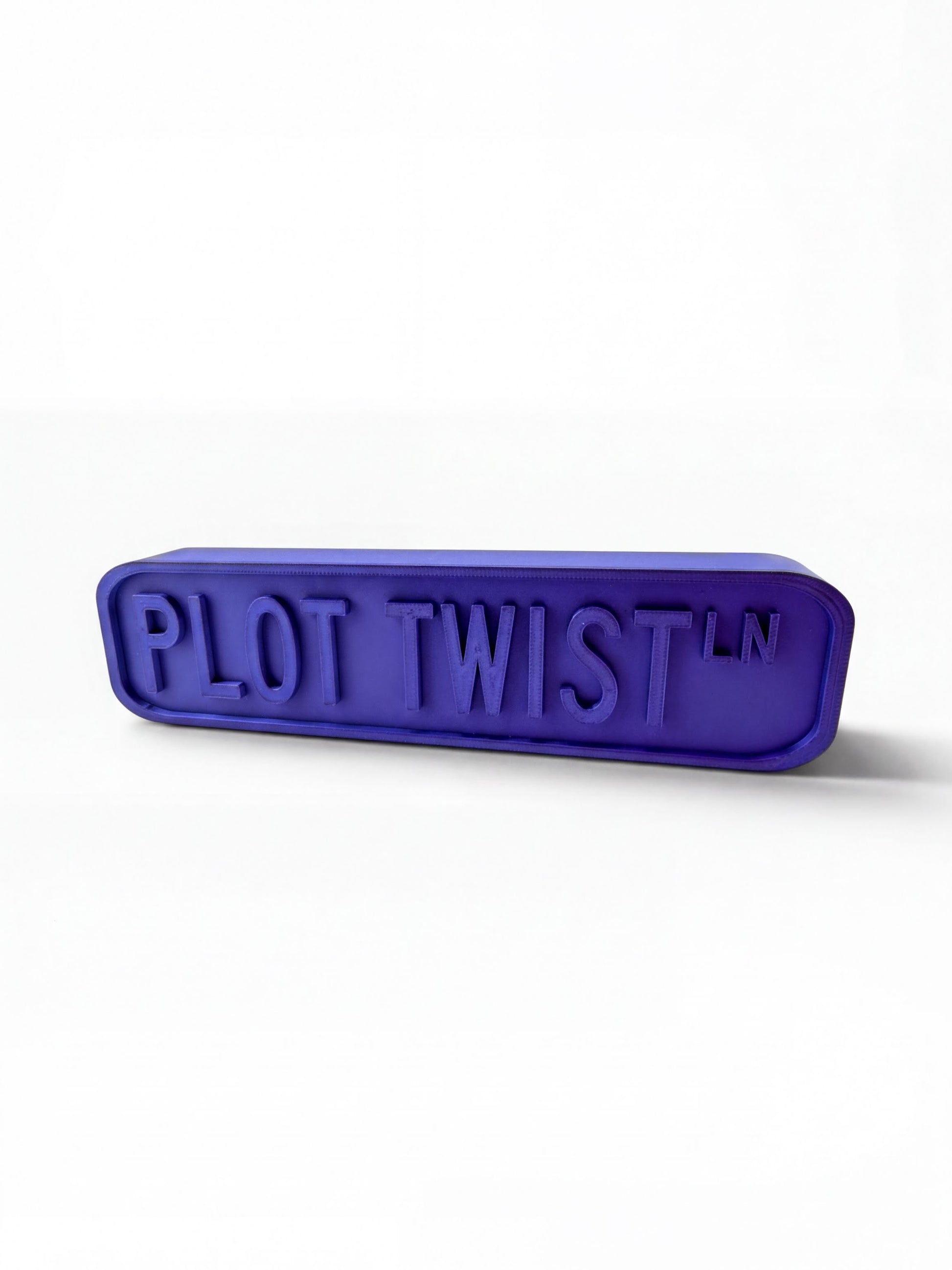 A purple rectangular object with the text "PLOT TWIST" embossed on it.
