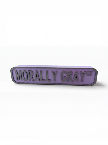 A purple rectangular sign with the text "Morally Gray" on it.