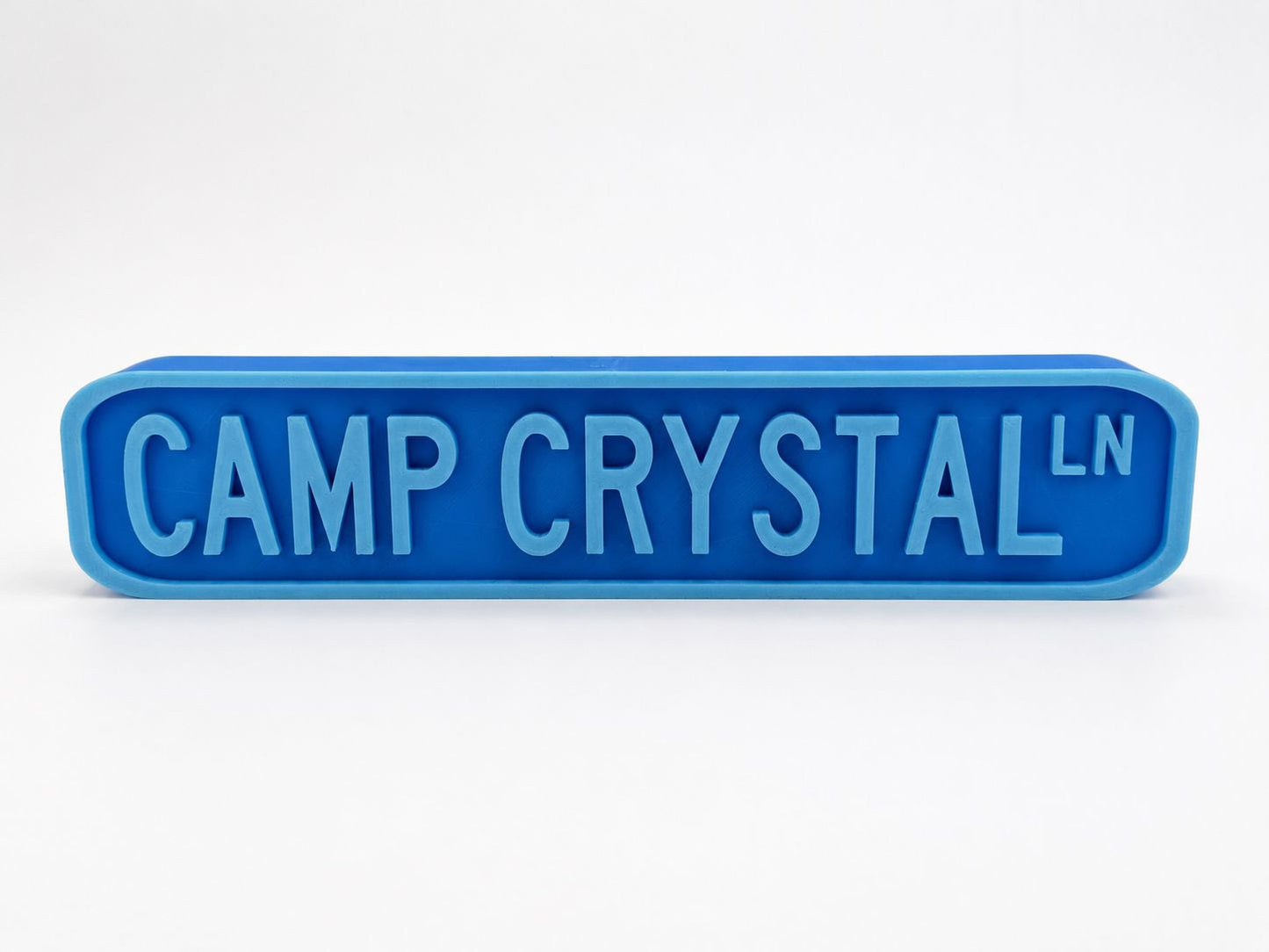 A blue rectangular sign with the text "CAMP CRYSTAL" in large letters.