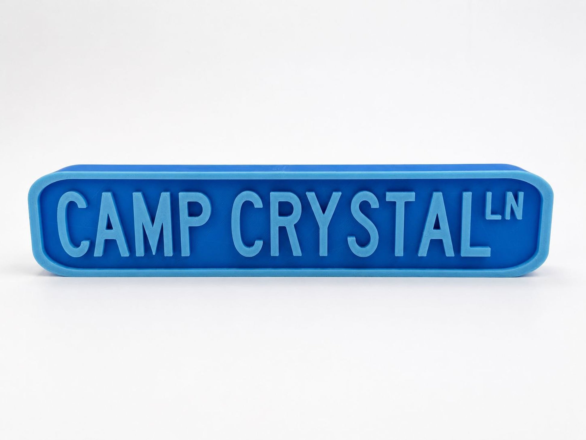 A blue rectangular sign with the text "CAMP CRYSTAL" in large letters.