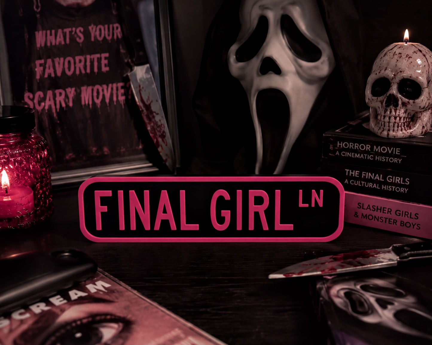 a collection of items related to the movie "Final Girl", including a sign, a skull, a candle, and some books.