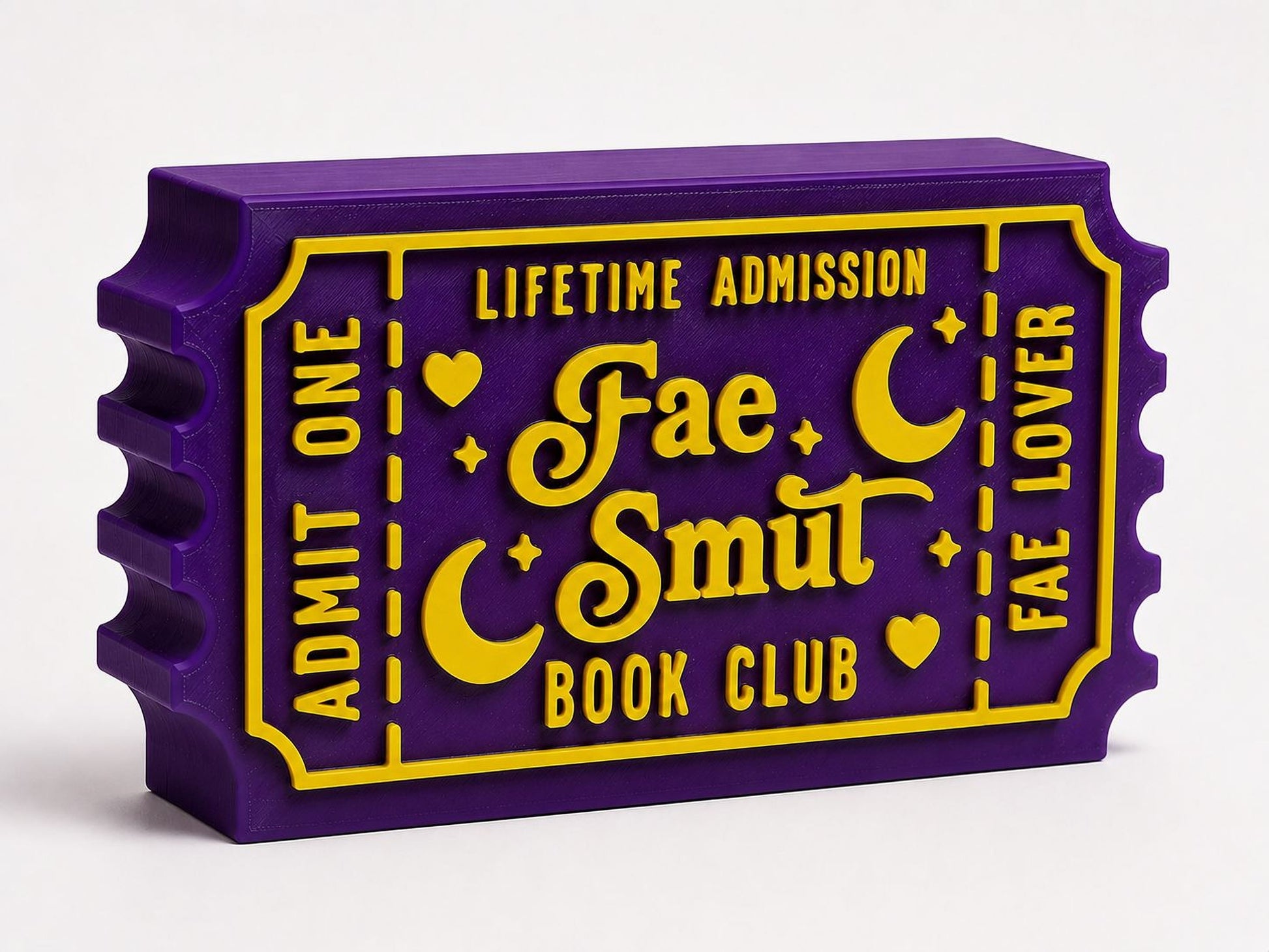 A purple and yellow ticket-shaped object with text that reads "Lifetime Admission Fae Smut Book Club".