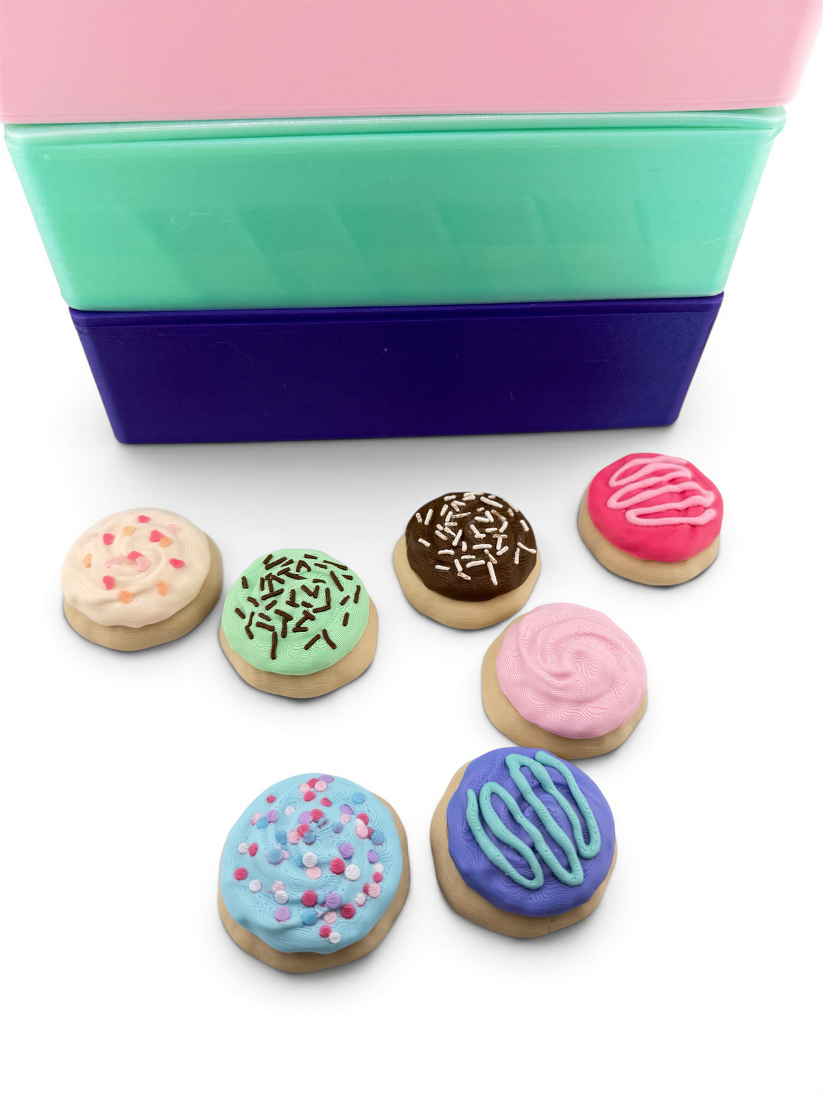 A collection of colorful, frosted cookies with various toppings, including sprinkles, arranged on a white surface.