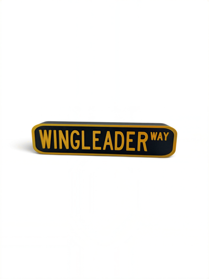 A rectangular sign with the text "WINGLEADER WAY" in bold yellow letters.
