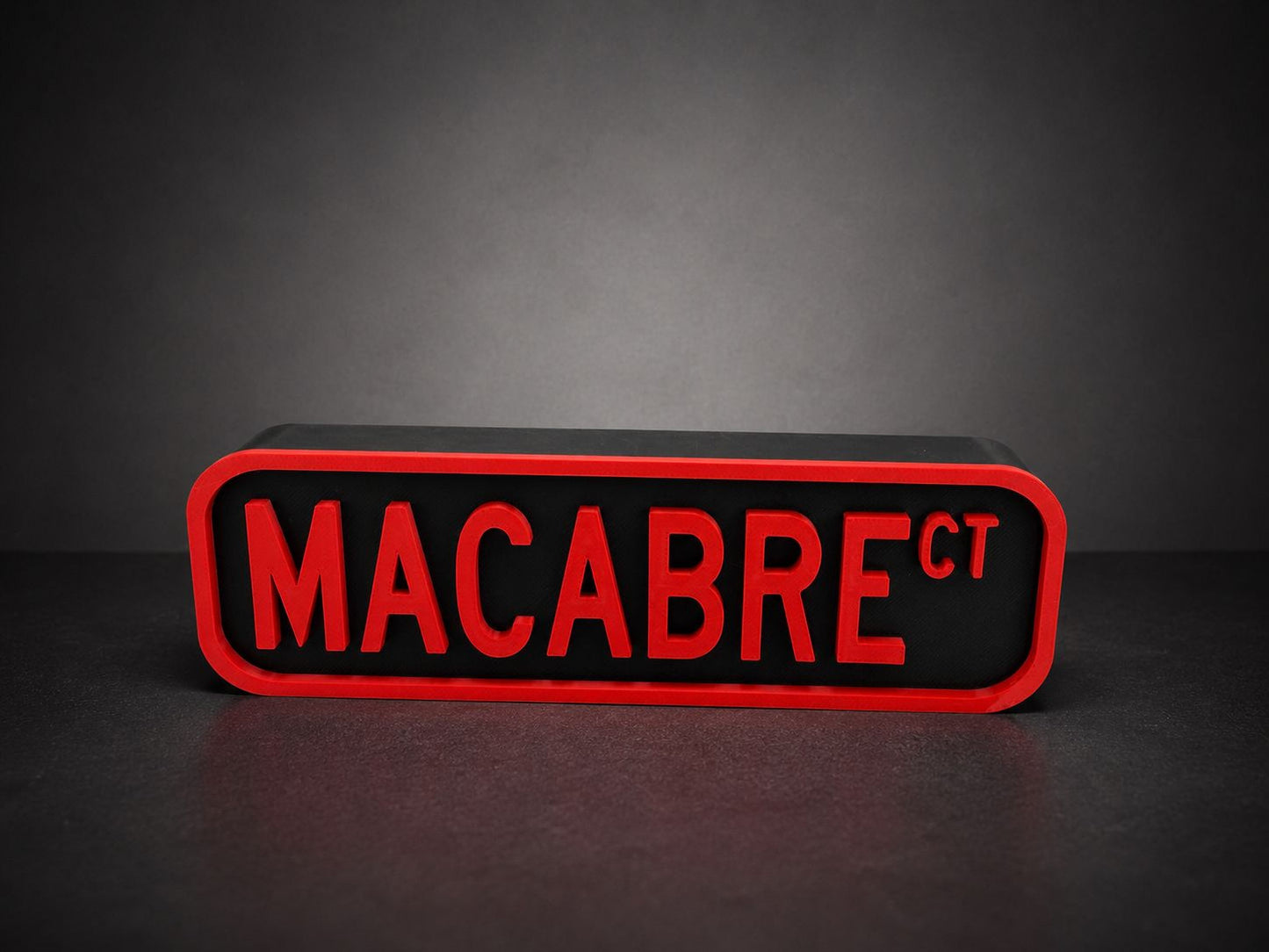 A red and black rectangular sign with the text "MACABRE" in bold red letters.