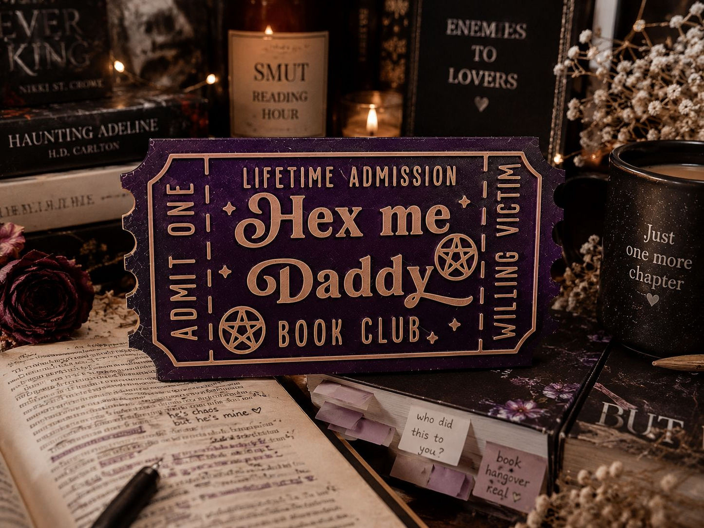 a purple ticket-shaped object with text, surrounded by various books, candles, and other items, creating a cozy and mysterious atmosphere.