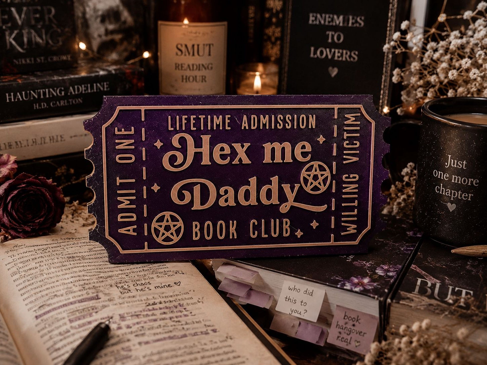 a purple ticket-shaped object with text, surrounded by various books, candles, and other items, creating a cozy and mysterious atmosphere.