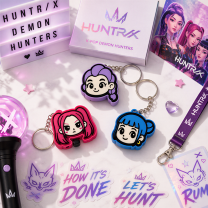 various items related to the K-pop group HUNTRX, including keychains, stickers, and a lanyard.