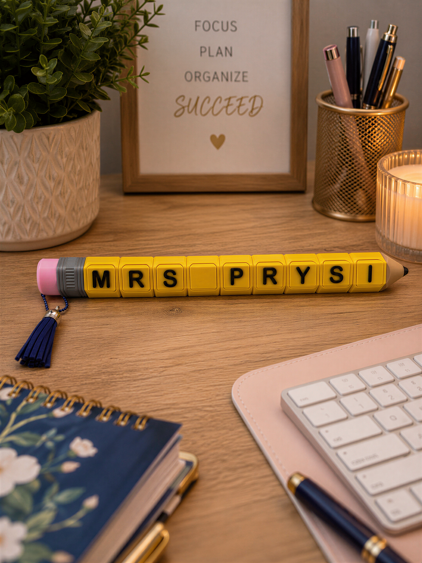 A wooden desk with various office supplies and a framed motivational quote.