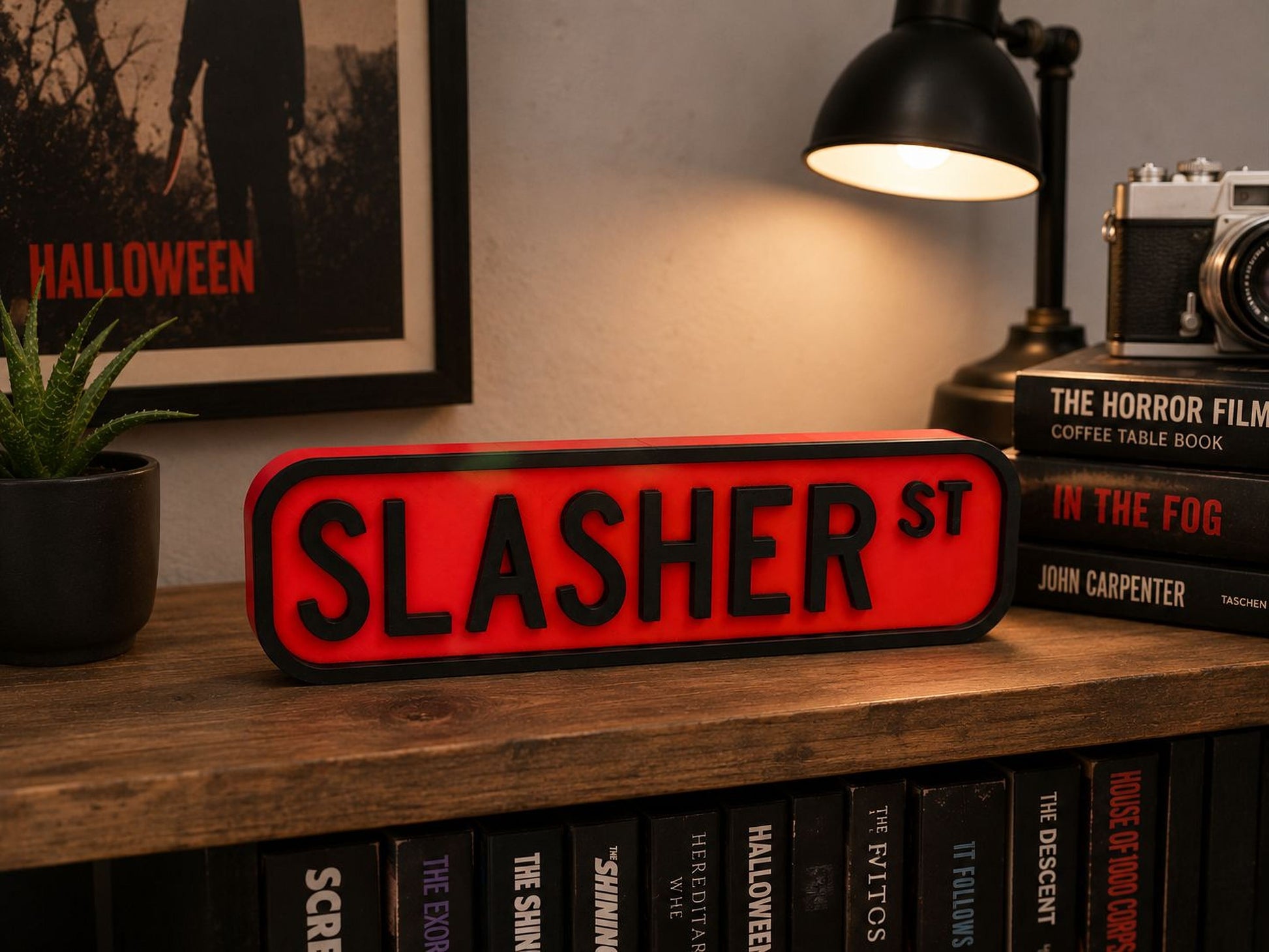 a shelf with a red sign that says "SLASHER ST" and a black lamp, surrounded by various books and a framed poster.