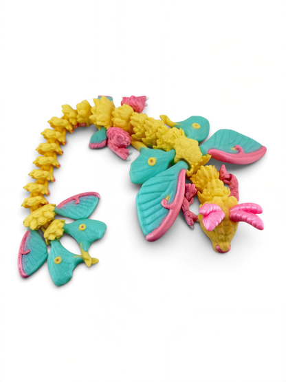 A colorful toy dragon made of plastic, featuring a combination of yellow, pink, and blue colors.