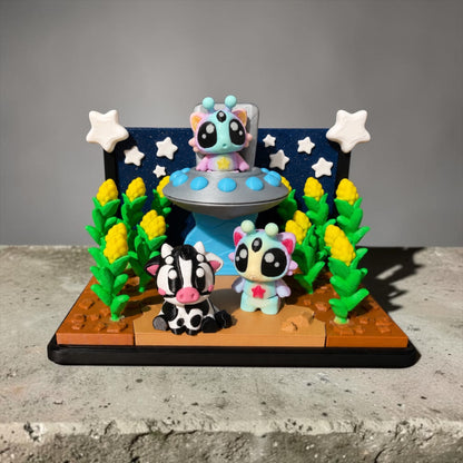 A whimsical scene featuring three small, colorful figurines of animals, including a cow, a cat, and a bird, set against a backdrop of a spaceship and stars.