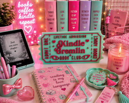 a collection of pink and teal-colored items, including a Kindle e-reader, a notebook, a candle, and various accessories, all arranged on a pink surface.