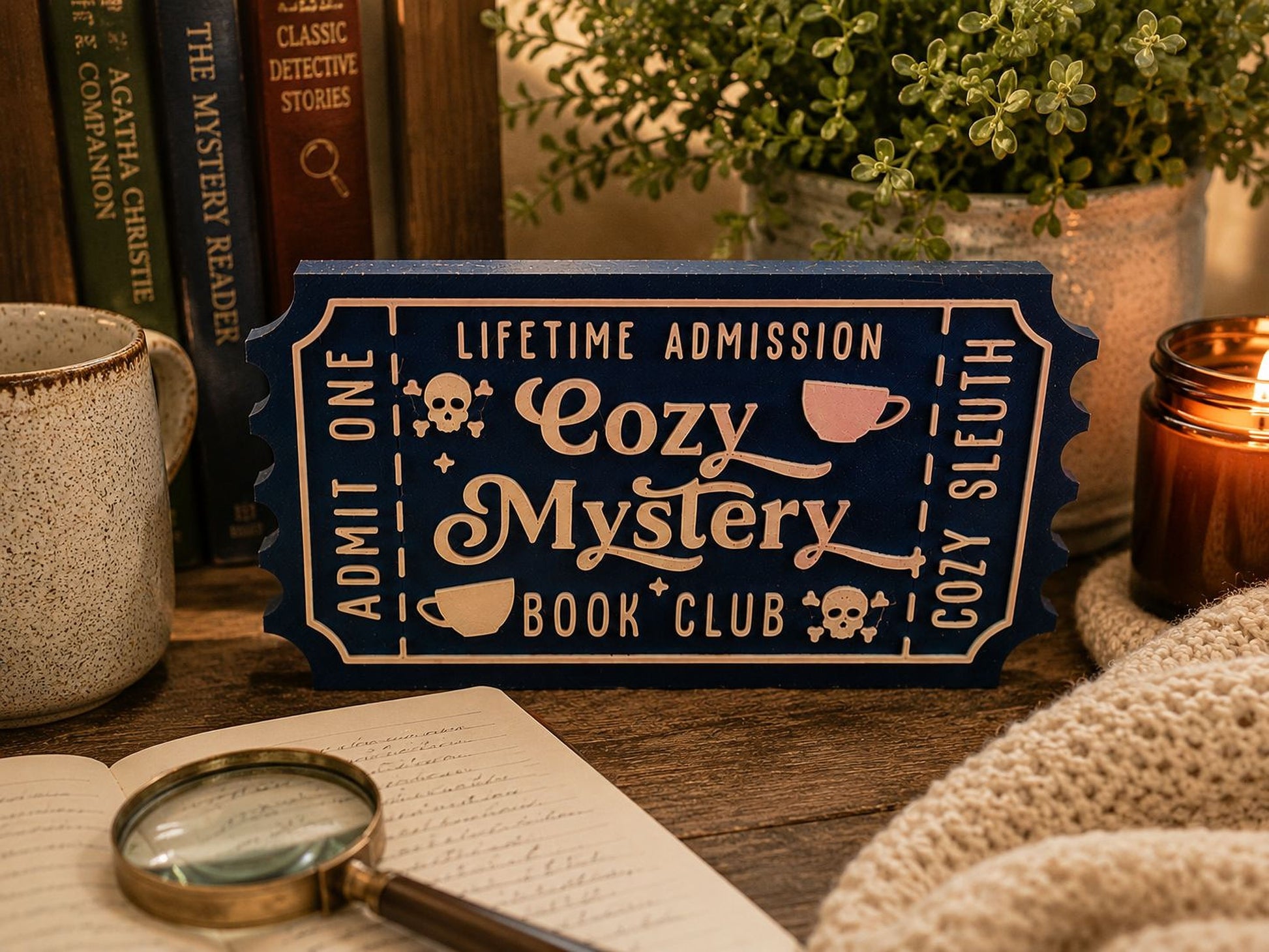 a blue sign with white text that reads "Lifetime Admission Cozy Mystery Book Club", surrounded by various objects such as a magnifying glass, a candle, and a book.
