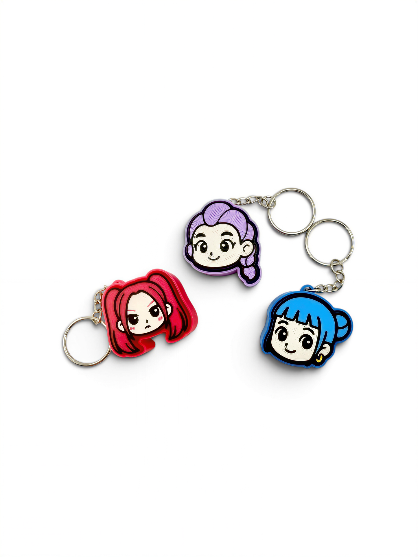 three keychains with cartoon-style female characters on them.