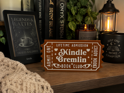a wooden shelf with various items, including a Kindle e-reader, a candle, a mug, and a book titled "Legends & Latte's".