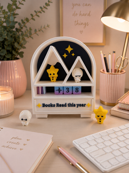 A desk with various items, including a white bookshelf with a sign that says "Books Read this year", a keyboard, a candle, and some small figurines.