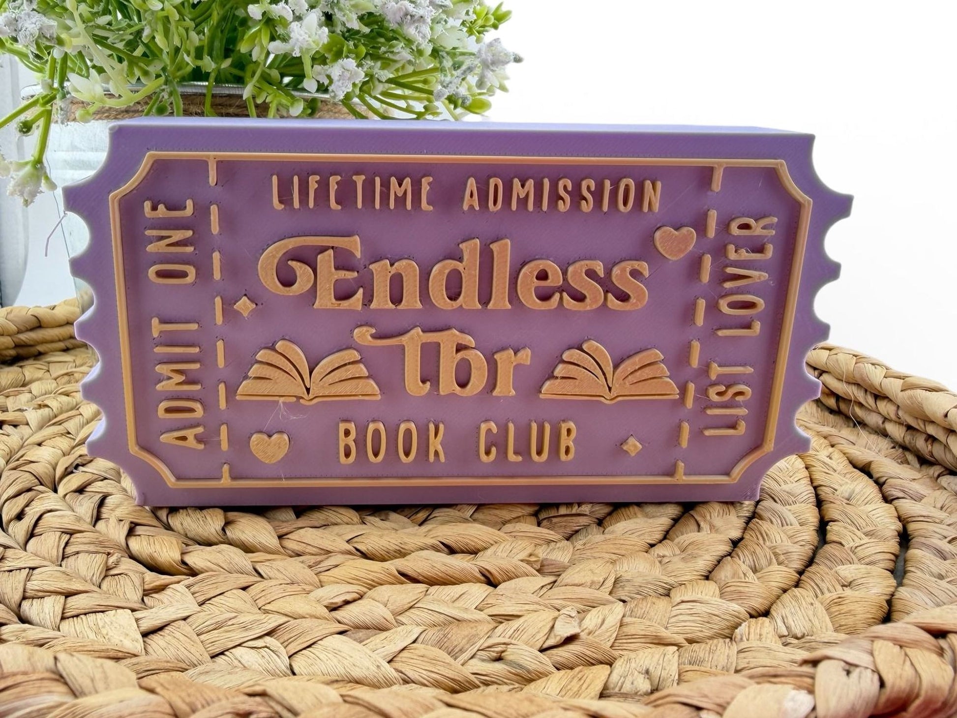 A purple ticket-shaped object with text and symbols, placed on a woven surface.