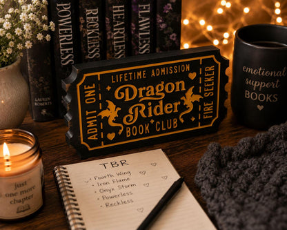a cozy scene with a candle, a notebook, and a mug, all arranged on a wooden surface.