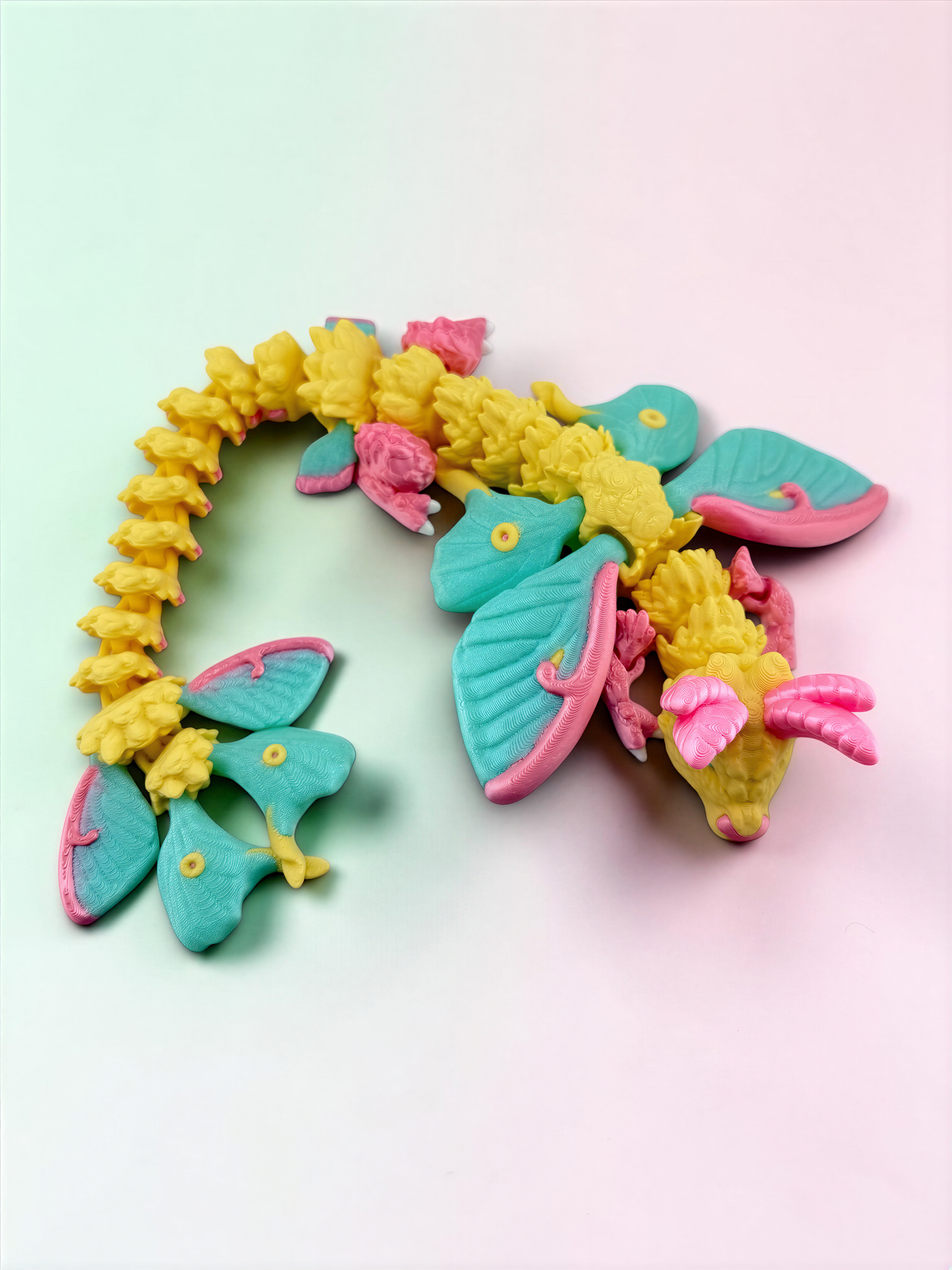 A colorful toy dragon made of small, brightly colored plastic pieces in shades of yellow, pink, and blue.