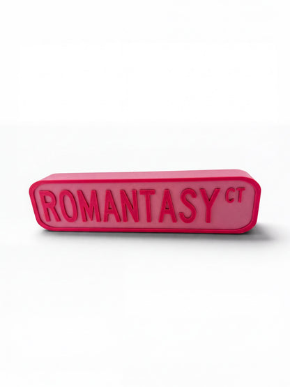 A pink rectangular object with the text "ROMANTASY" in large, bold letters.